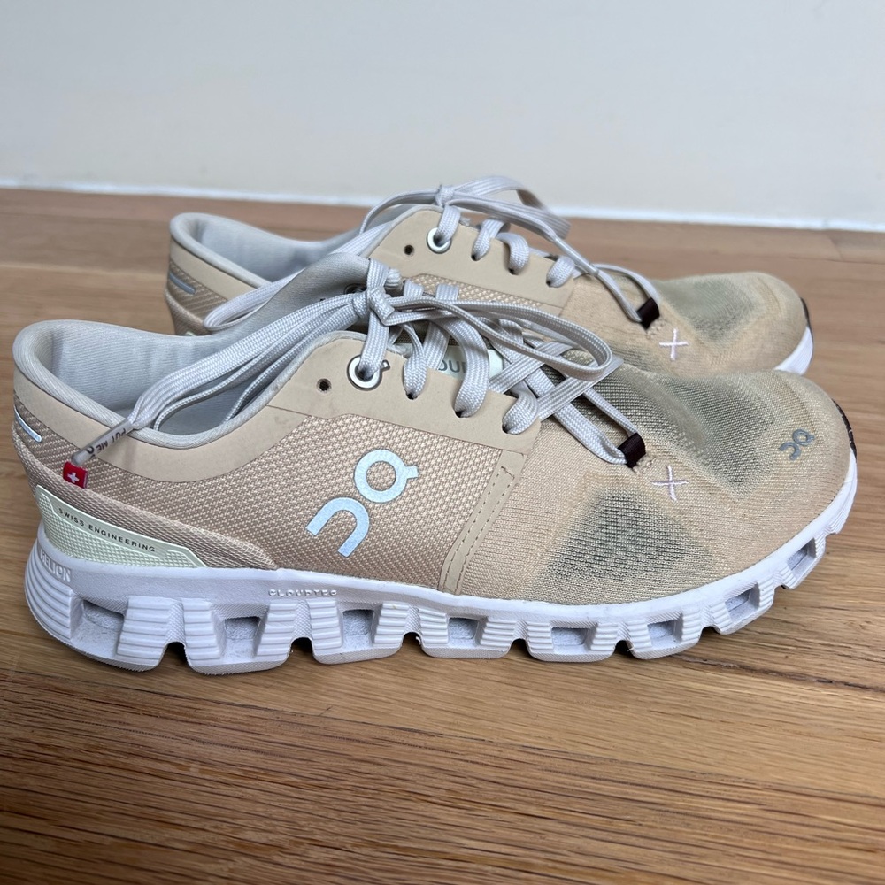 On Running Sand and White Athletic Shoes